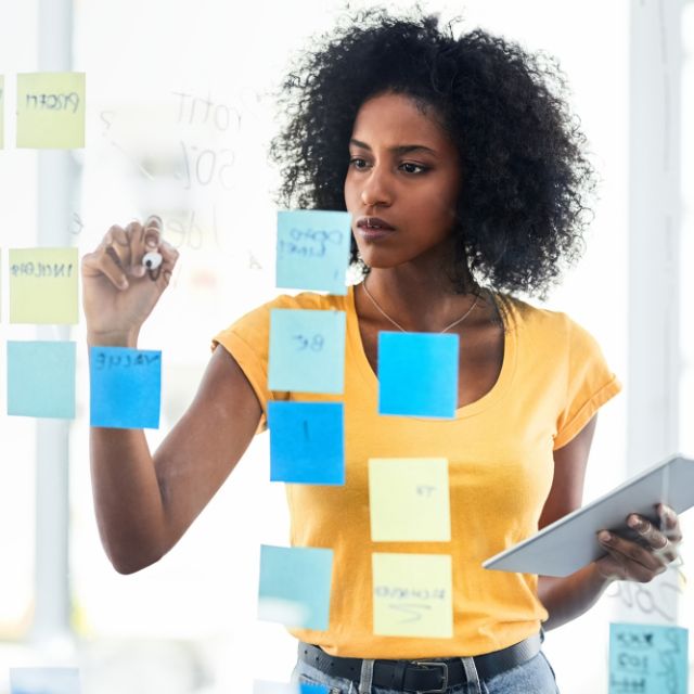 woman writing on sticky notes